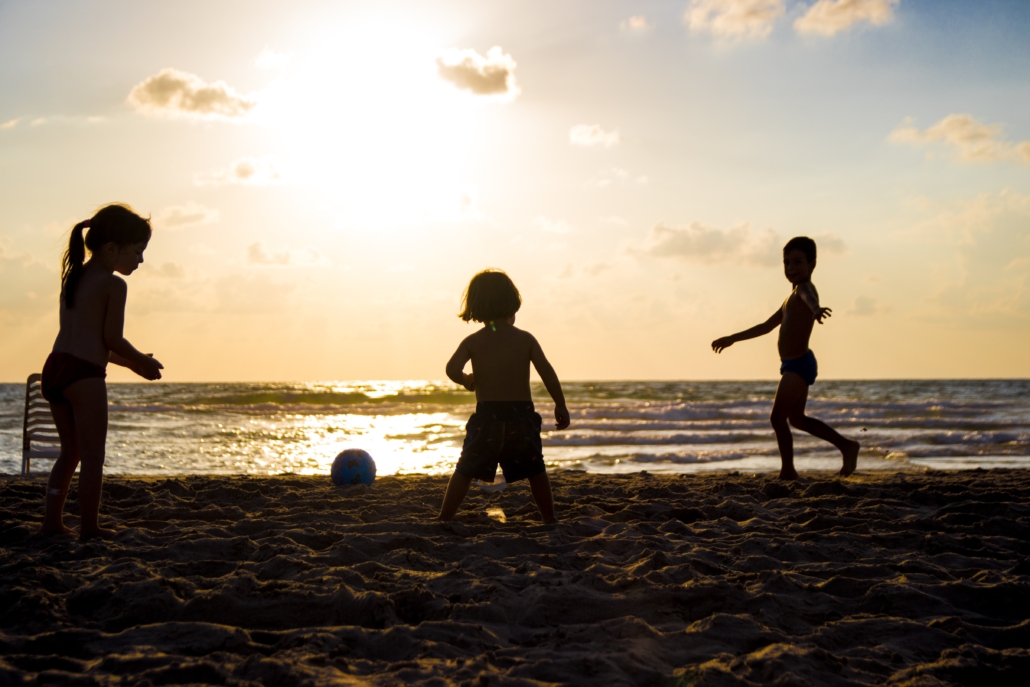 young children playing on the beach