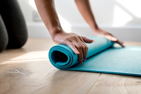 rolling up a blue yoga mat