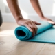 rolling up a blue yoga mat
