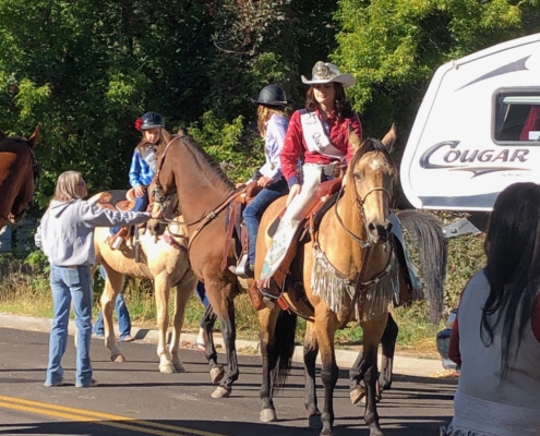 women on horseback wearing cowboy hats while in a parade