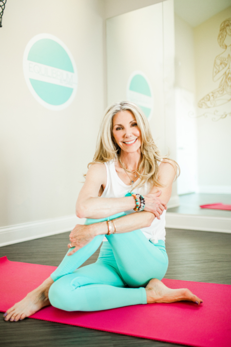 cynthia delaney smiling on a yoga mat