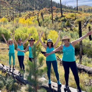 yoga attendees having a blast standing on a log while hiking