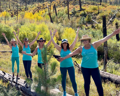 yoga attendees having a blast standing on a log while hiking